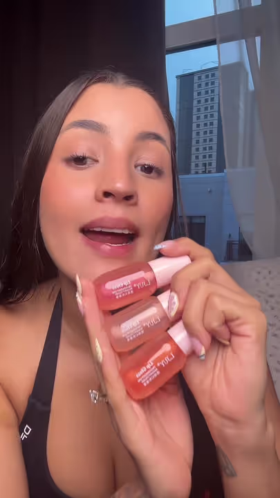 Luisa showing lip gloss in a makeup review